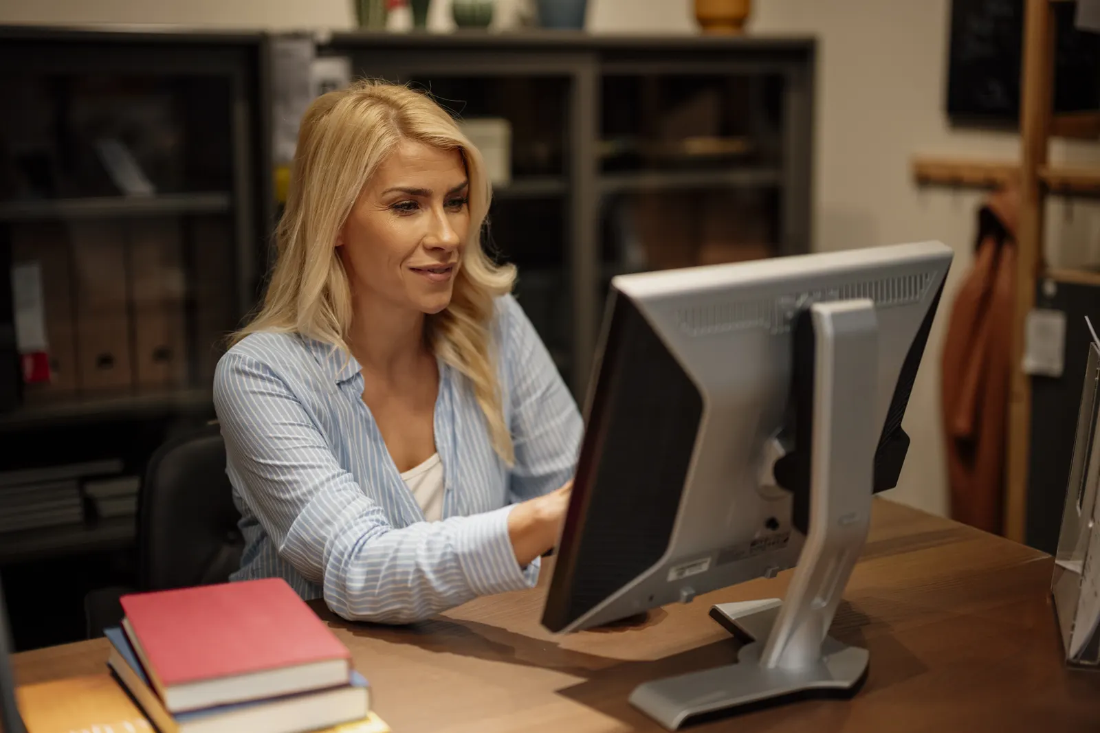 Atendente trabalhando no computador em um escritório